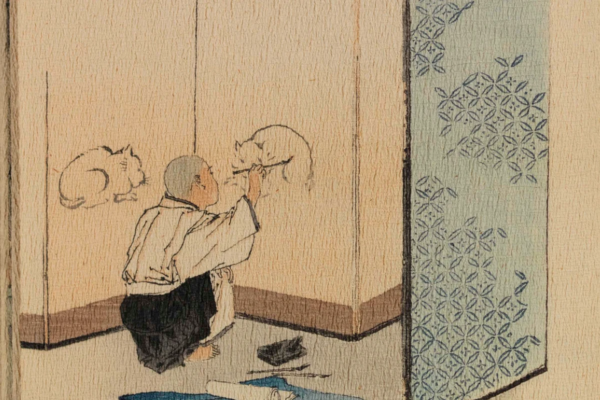 A young Japanese boy paints two cats on a temple screen with an ink brush