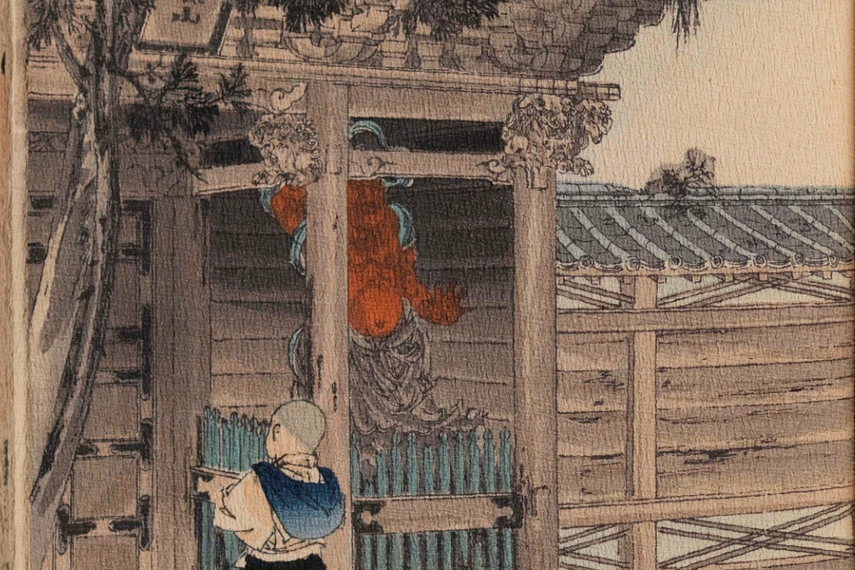 A young Japanese boy carrying a bundle approaches the gate of an old temple