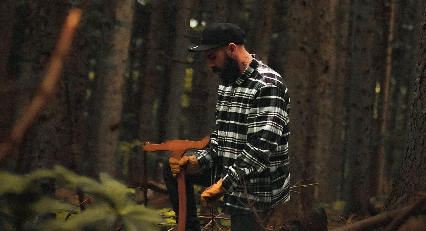 An honest woodcutter holding his axe in a quiet forest