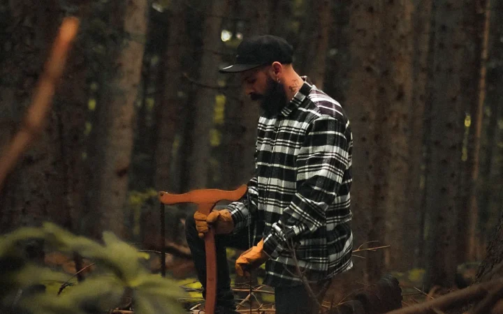 An honest woodcutter holding his axe in a quiet forest